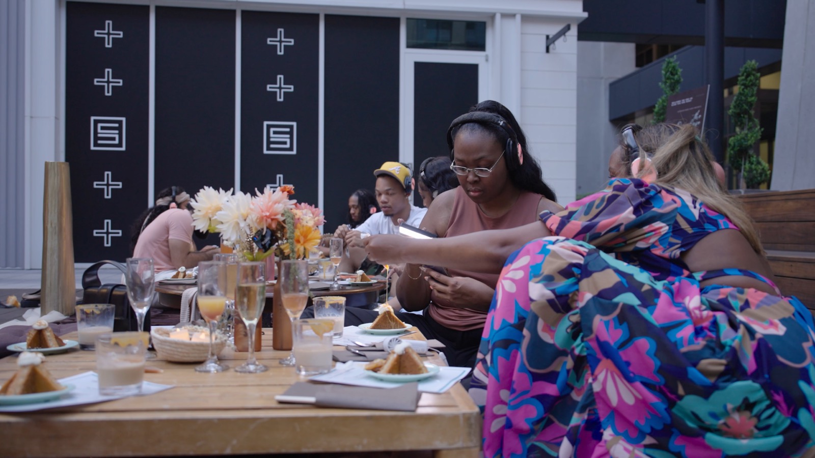 Guests seated along one long communal table, plates set at every place.