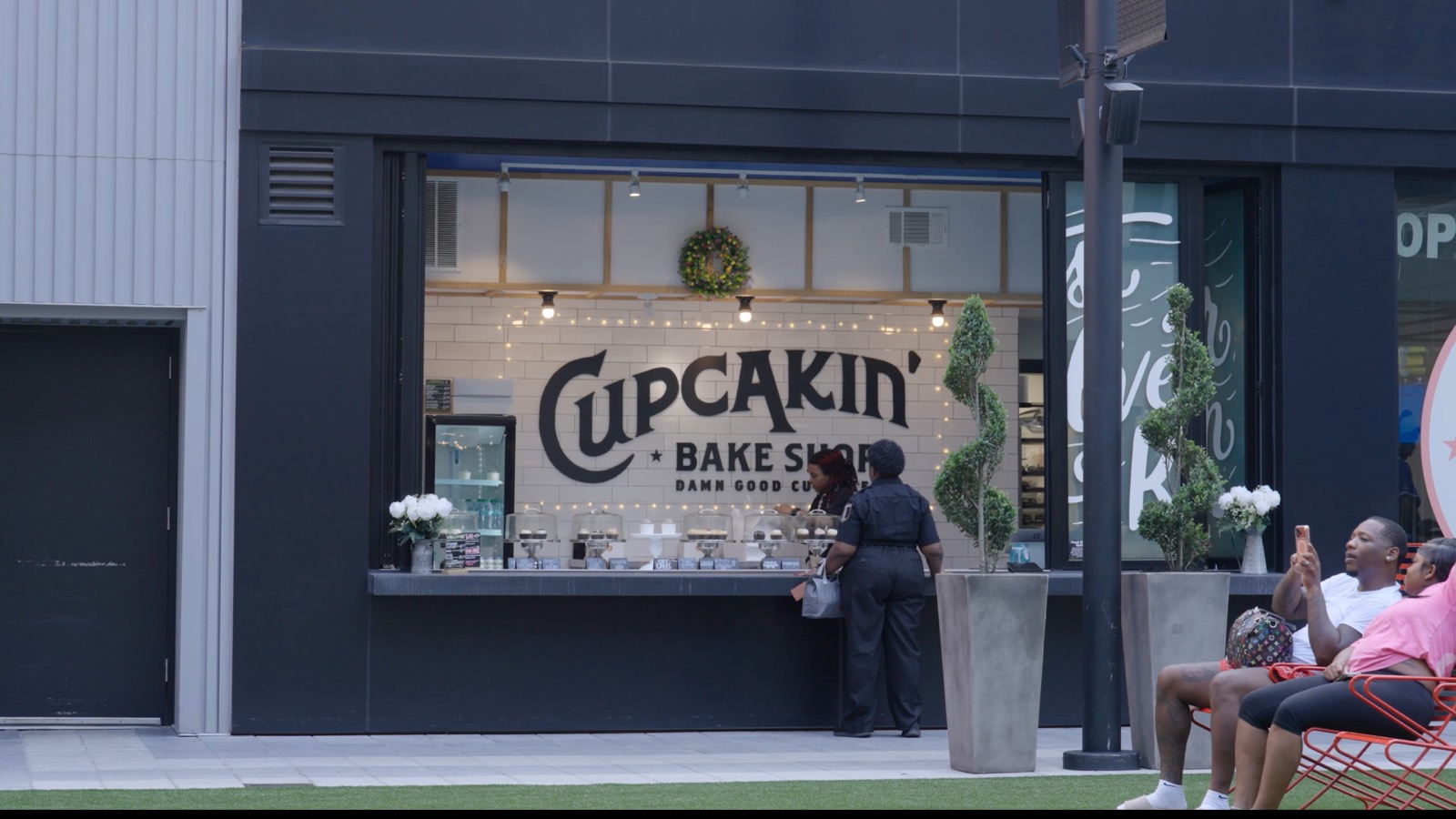 The Cupcakin' Bake Shop storefront window with cupcakes under glass cloches.